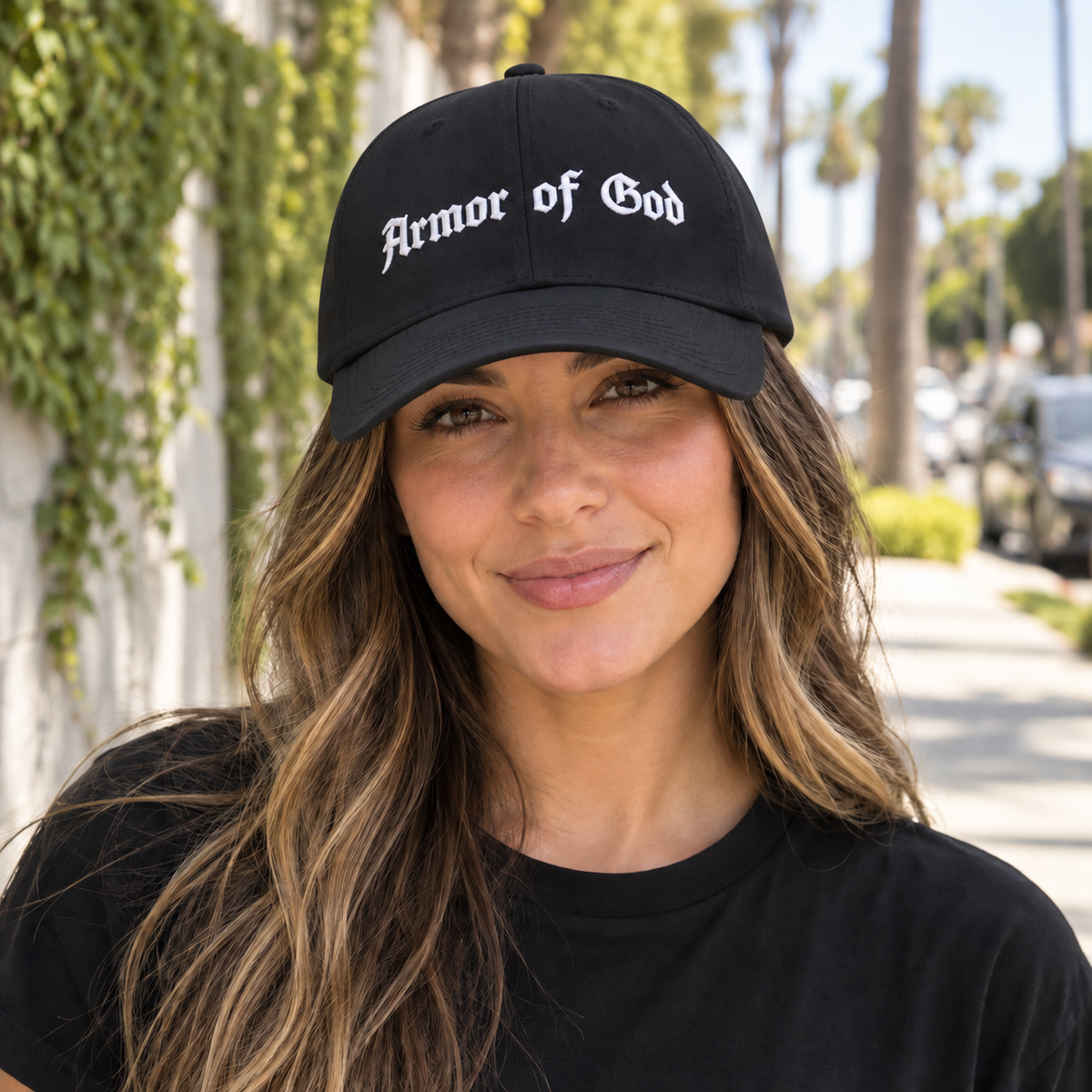 Female model wearing the Armor of God Dad Hat in black, close-up of the white front embroidery