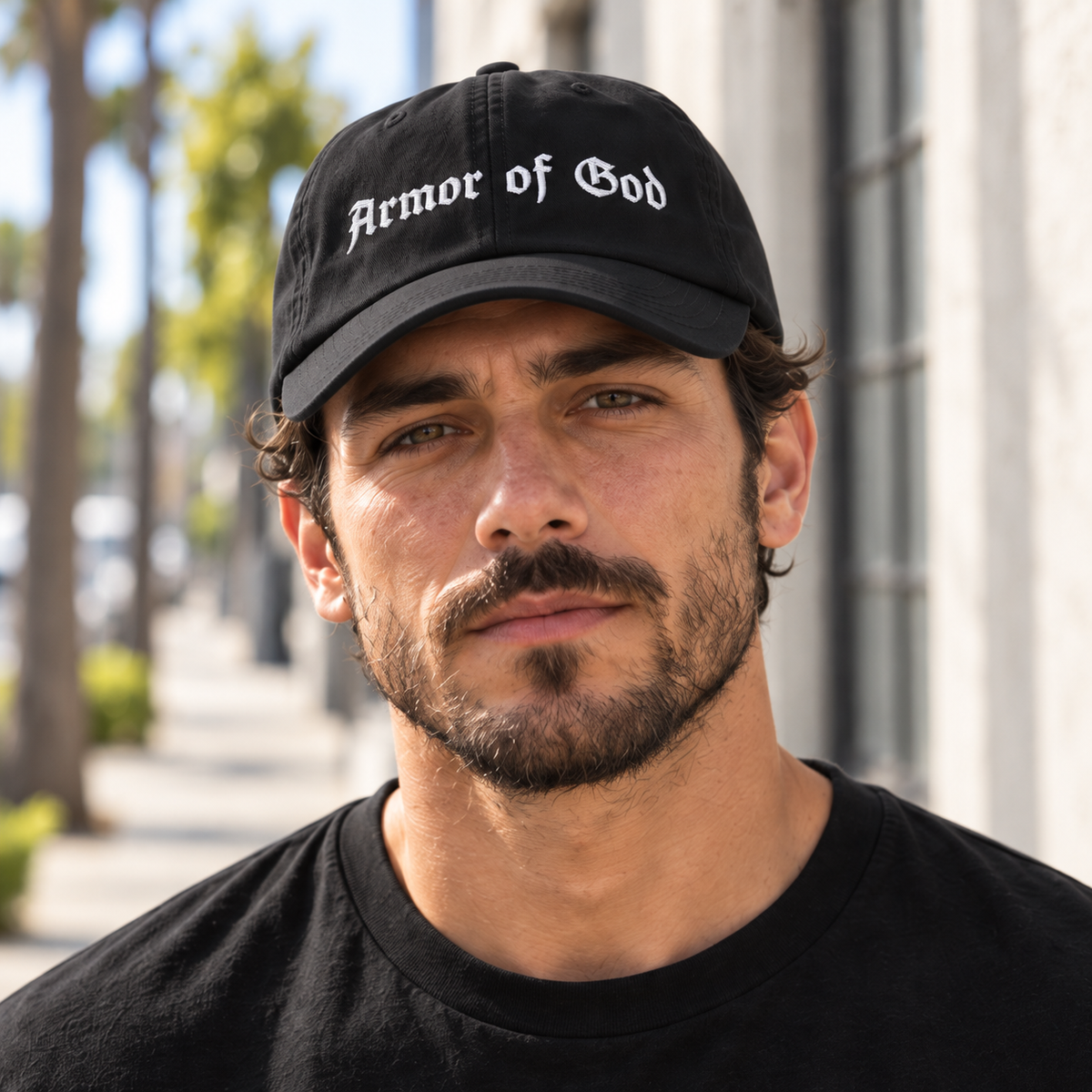 Male model wearing the Armor of God Dad Hat in black, close-up of the white front embroidery